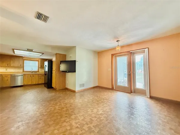 a view of a kitchen with an entryway and a refrigerator