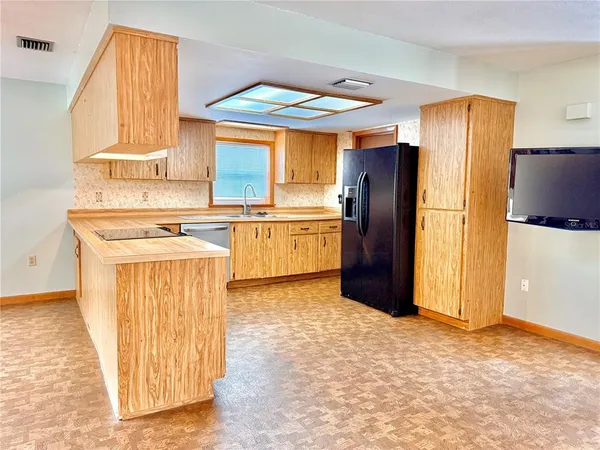 a kitchen with stainless steel appliances granite countertop a refrigerator a stove and a sink with granite countertops