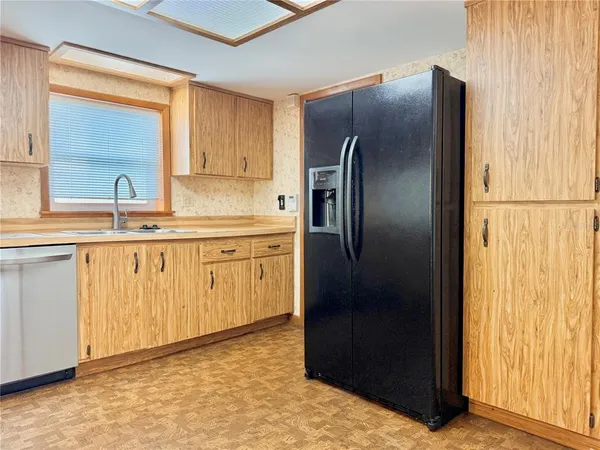 a kitchen with a refrigerator sink and cabinets