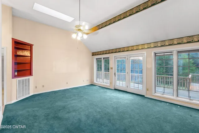 a view of empty room with a flat screen tv and dresser