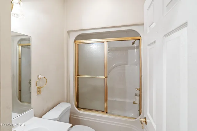 a bathroom with a sink a toilet and shower curtain