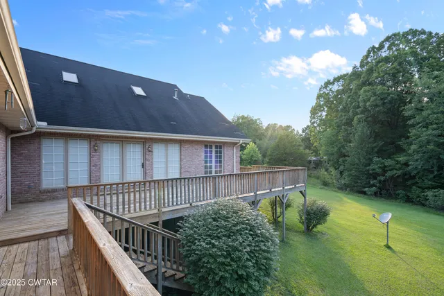 a balcony with wooden floor and trees in the background