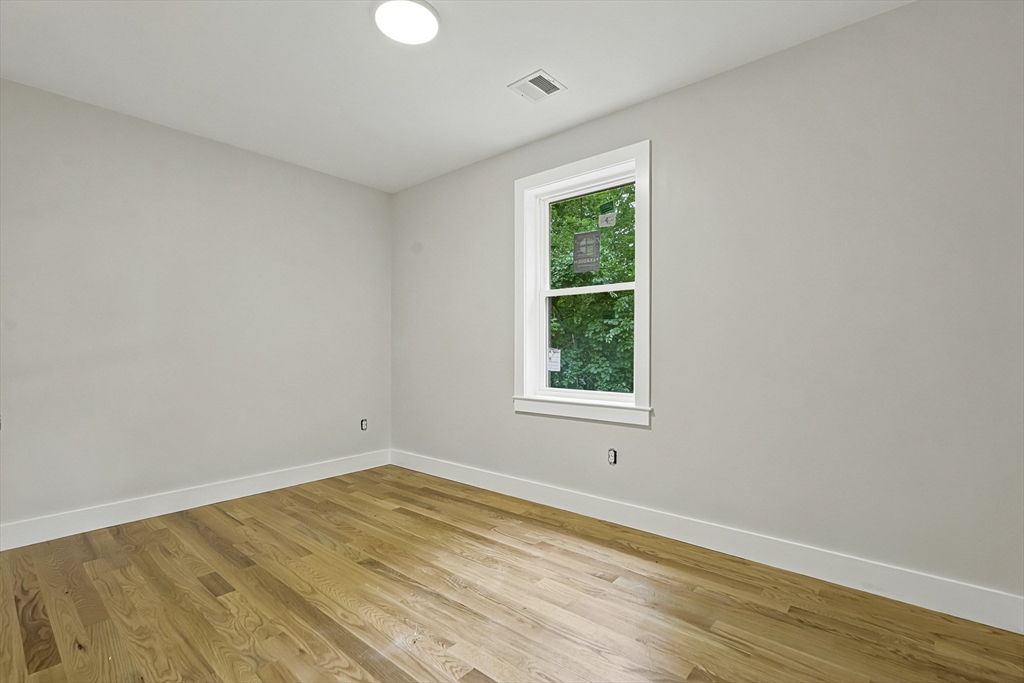 4 Mayhew Street Framingham, MA 01702 - Photo 29 of 42 an empty room with wooden floor and windows