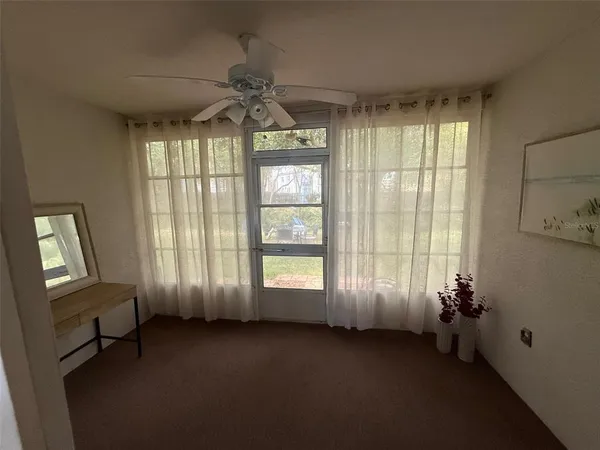 a view of a bedroom with a window and wooden floor