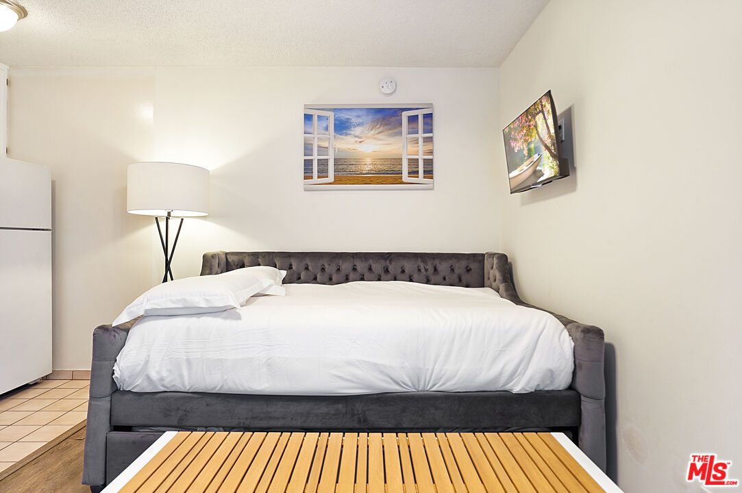 3720 Vinton Avenue, Unit 1A Los Angeles, CA 90034 - Photo 13 of 15 a bed sitting in a bedroom and a lamp