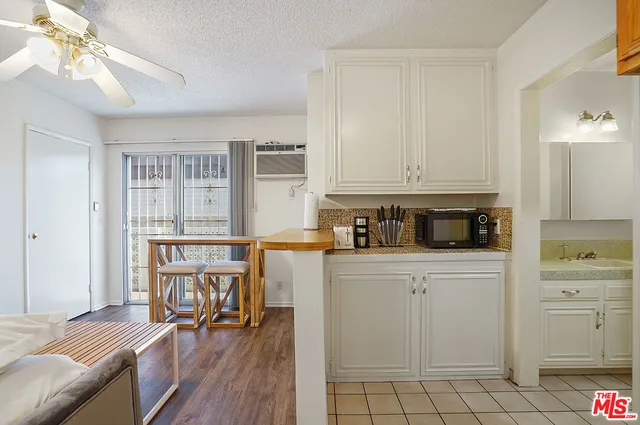 a kitchen with white cabinets and sink