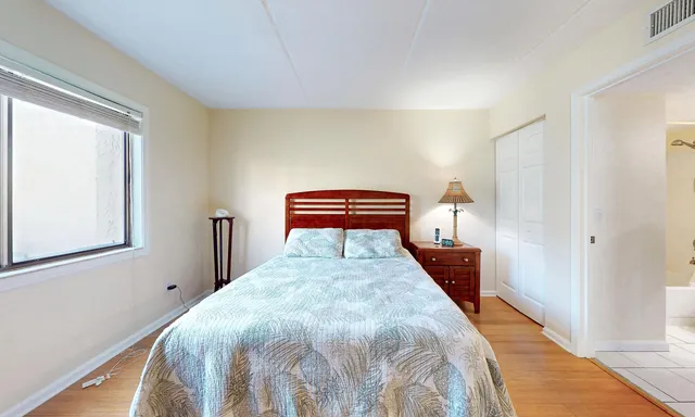 a spacious bedroom with a bed and a dresser in it