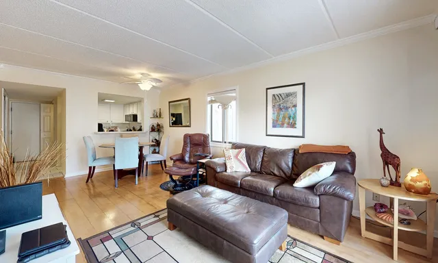 a living room with furniture kitchen view and a window