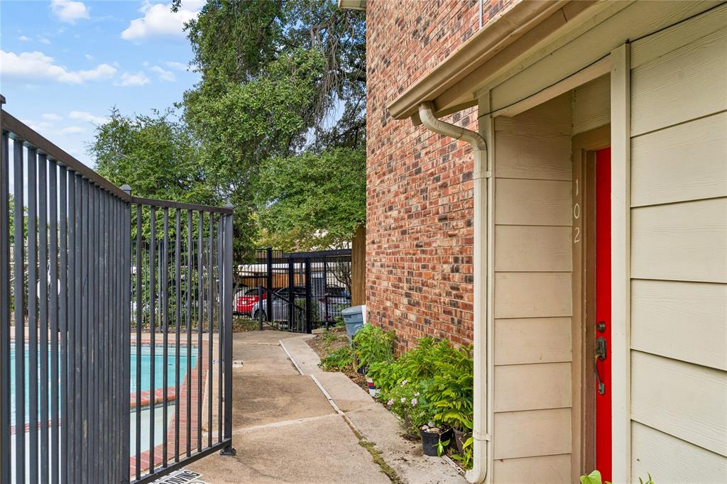 11311 Audelia Road, Unit 102 Dallas, TX 75243 - Photo 3 of 31 Red brick exterior with light-colored siding, a vibrant red entry door, and a concrete walkway