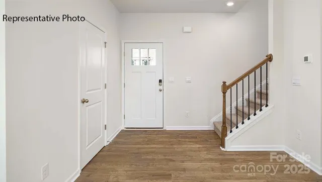 a view of a hallway with wooden floor and entryway