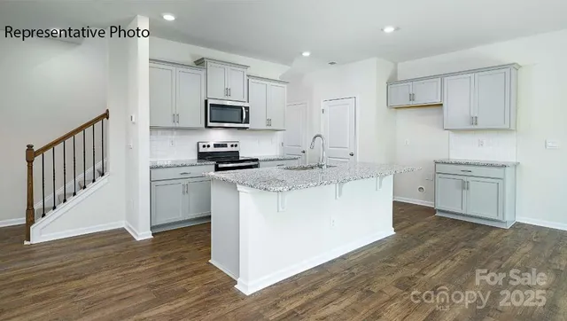 a kitchen with granite countertop white cabinets and white appliances