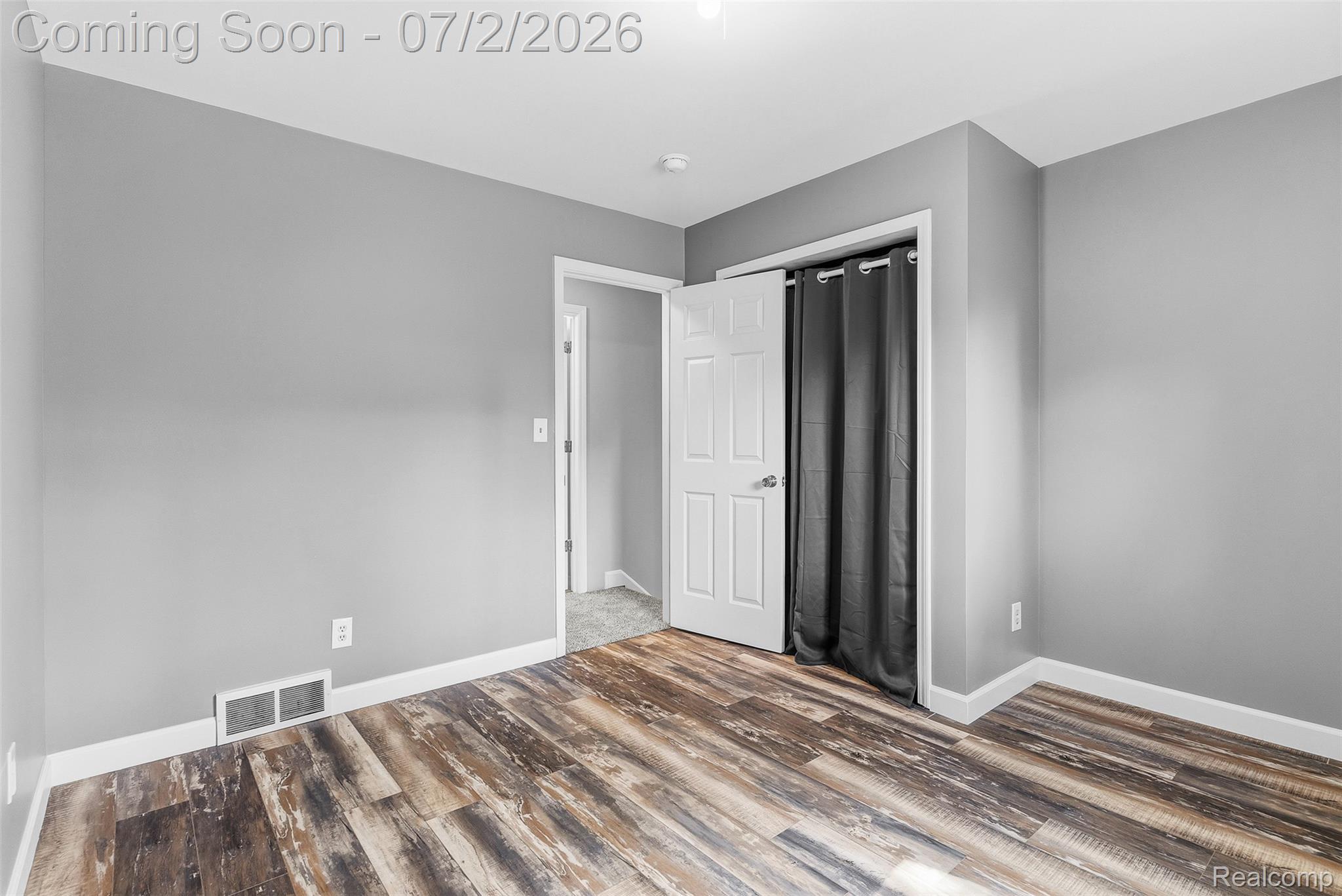 305 East Road Holly, MI 48442 - Photo 16 of 41 Room featuring wood-finish flooring, light grey walls, white baseboards, and a white interior door