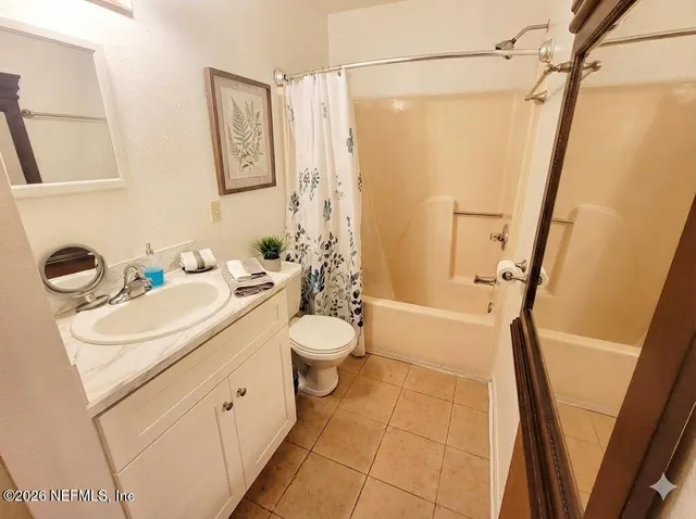 a bed sitting in a bedroom next to a lamp with dresser