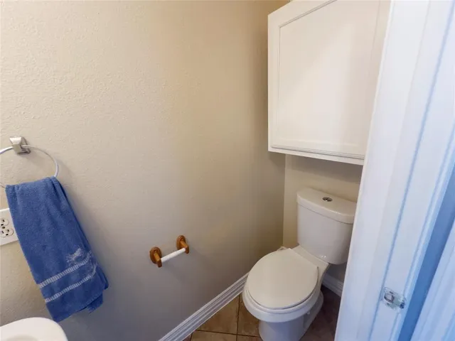 a white toilet sitting next to a wooden cabinet