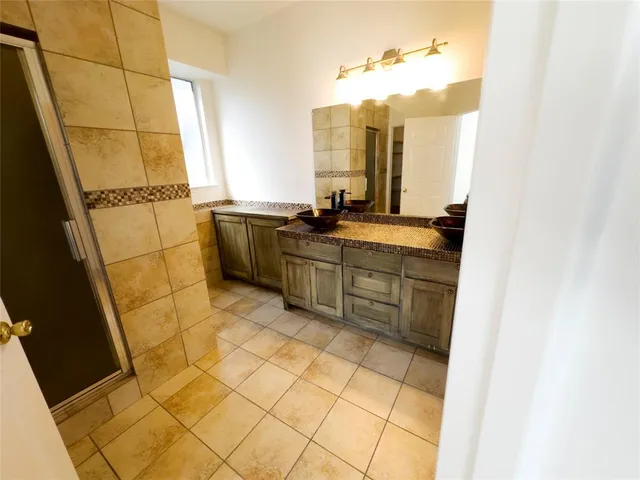 a bathroom with a sink mirror and a shower