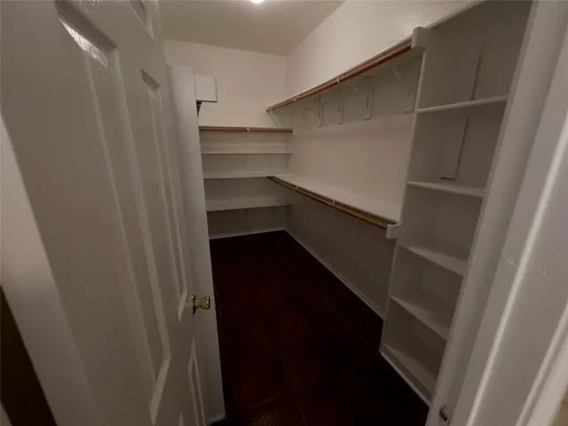 a view of walk in closet with empty racks