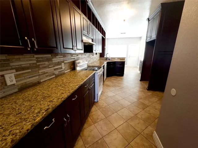 a kitchen with stainless steel appliances granite countertop a sink stove and cabinets