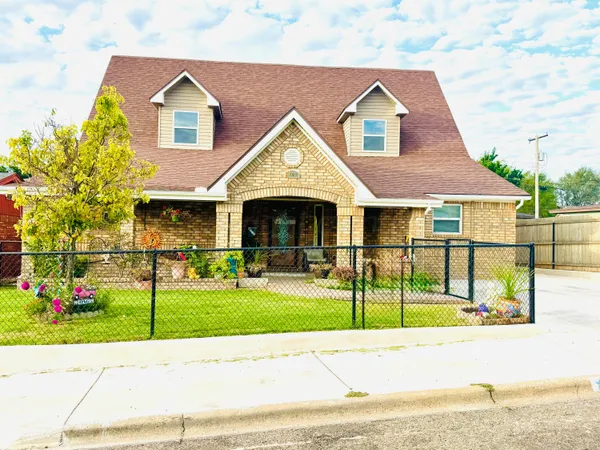 a view of a brick house with a yard in front of it