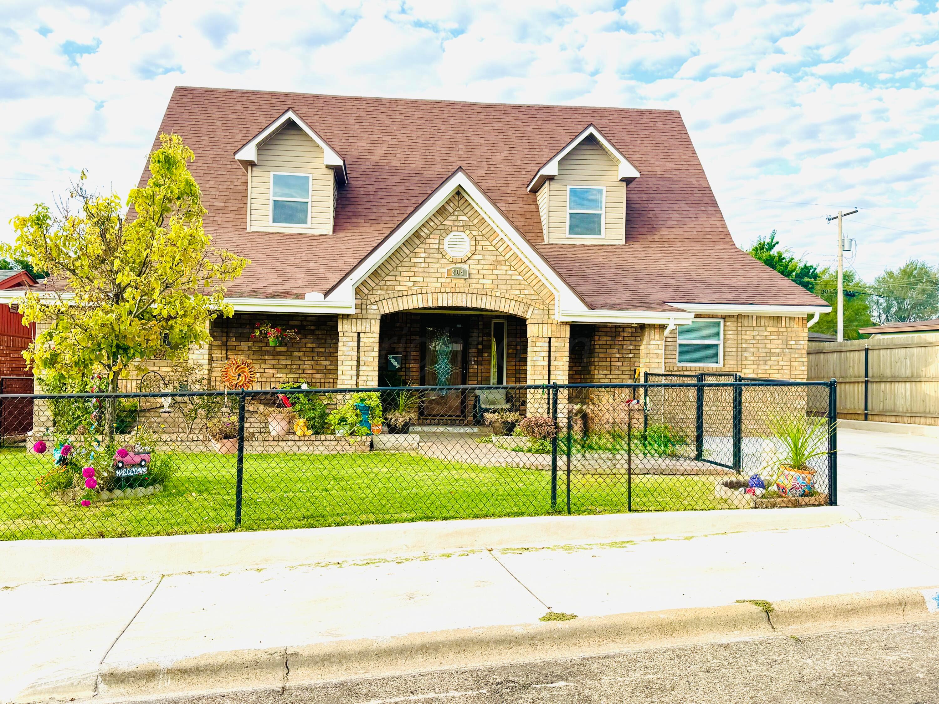 204 Garrett Street Borger, TX 79007 - Photo 1 of 23 a view of a brick house with a yard in front of it