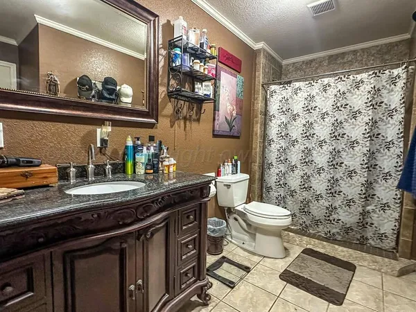 a bathroom with a sink a toilet and a shower curtain