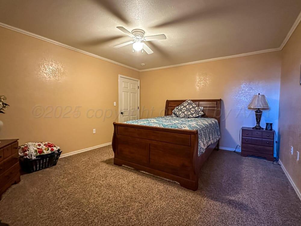 204 Garrett Street Borger, TX 79007 - Photo 18 of 23 a bedroom with a bed and a chandelier