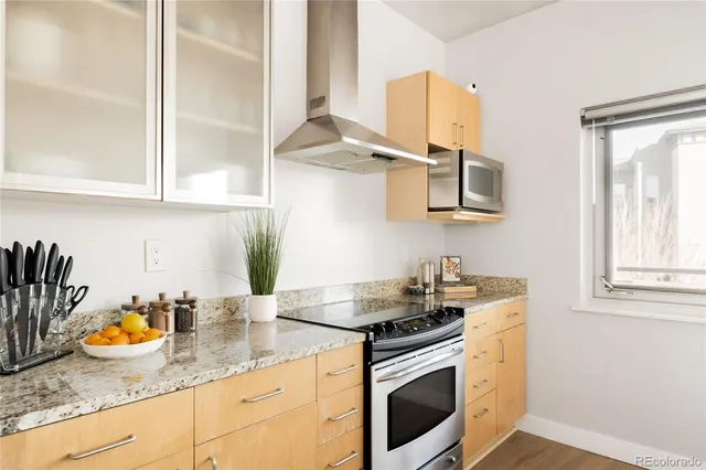 a kitchen with stainless steel appliances granite countertop a sink stove and cabinets