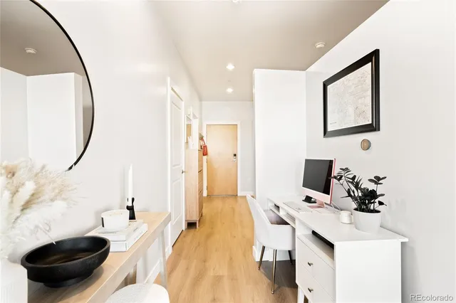 a view of a workspace with furniture and a mirror