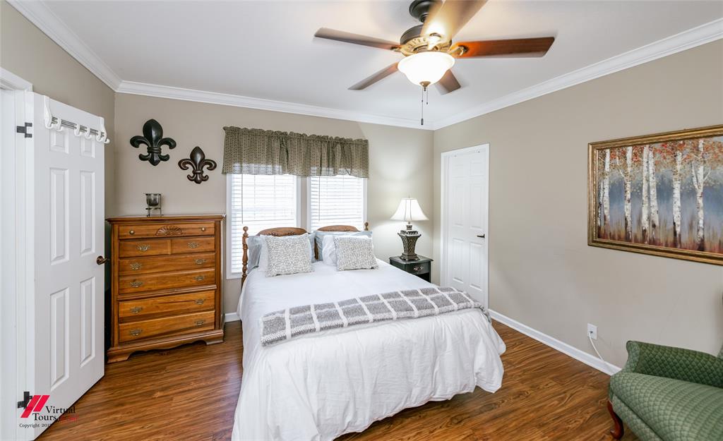 12501 Rust Lane Keithville, LA 71047 - Photo 26 of 39 a bedroom with a bed and a chandelier