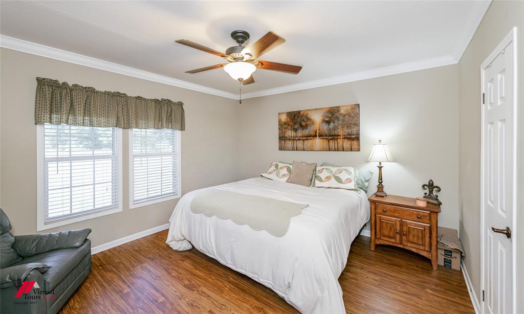 12501 Rust Lane Keithville, LA 71047 - Photo 28 of 39 a bedroom with a bed and a chandelier