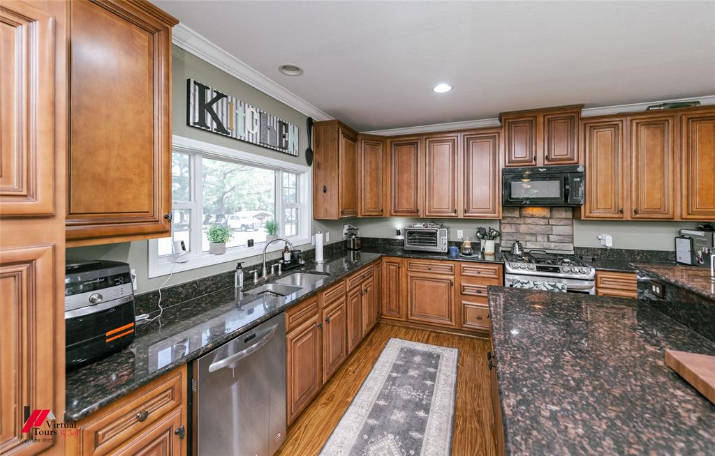 12501 Rust Lane Keithville, LA 71047 - Photo 8 of 39 a kitchen with stainless steel appliances granite countertop a stove a sink dishwasher and cabinets with wooden floor