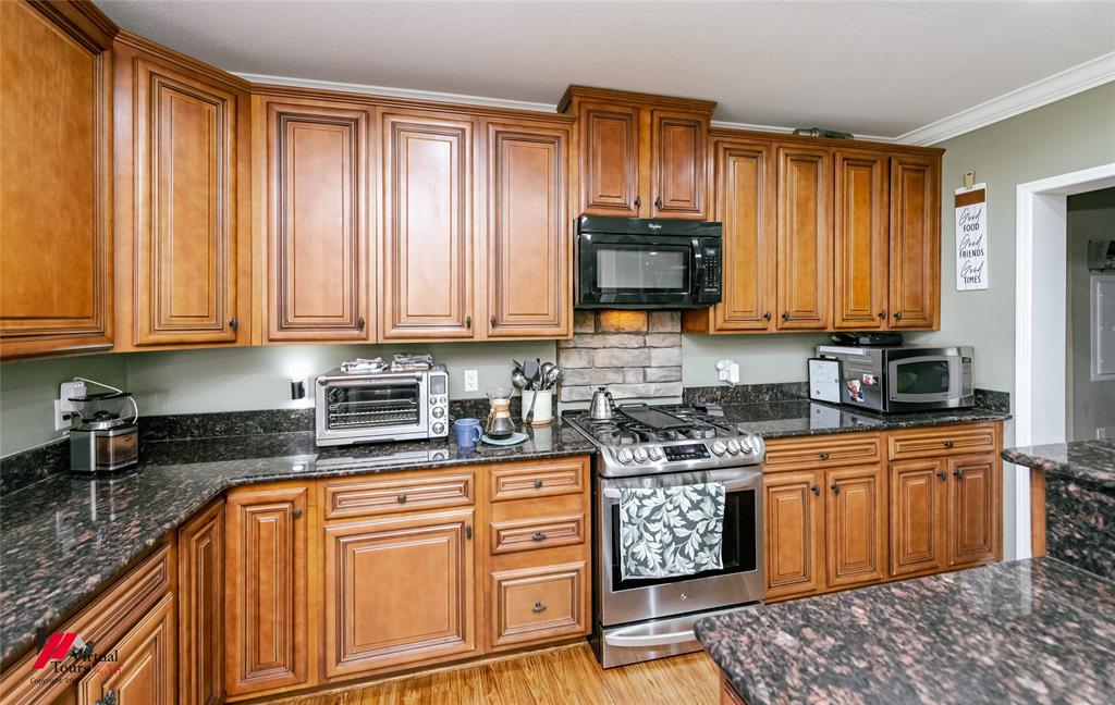 12501 Rust Lane Keithville, LA 71047 - Photo 9 of 39 a kitchen with stainless steel appliances granite countertop a stove sink microwave and cabinets