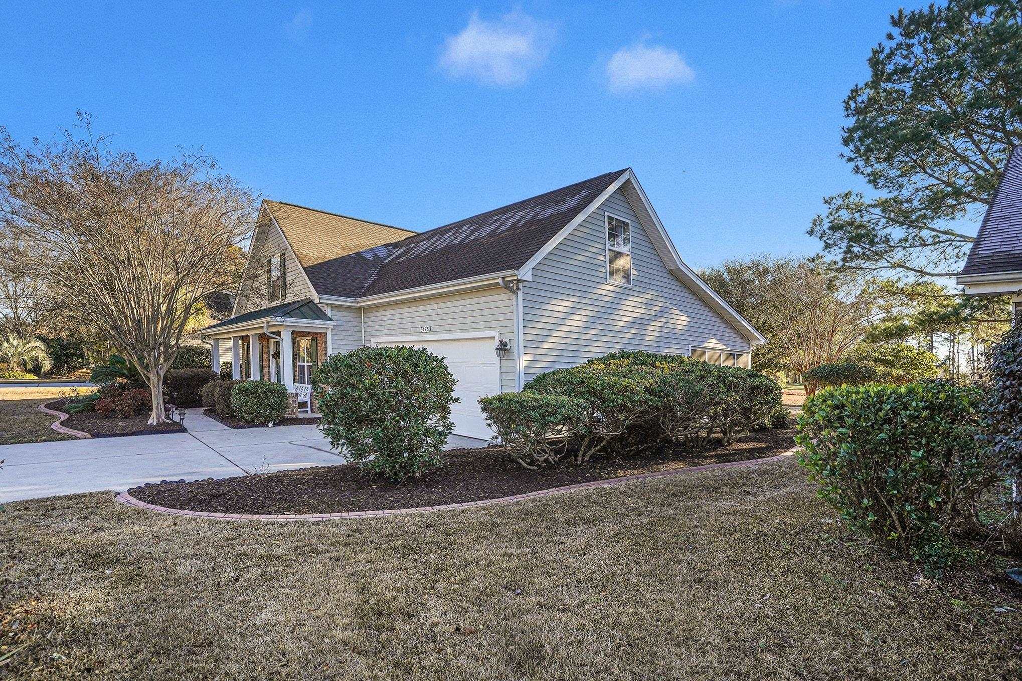 3425 Arrowhead Boulevard Myrtle Beach, SC 29579 - Photo 2 of 38 View of side of home with a lawn, driveway, and a shingled roof