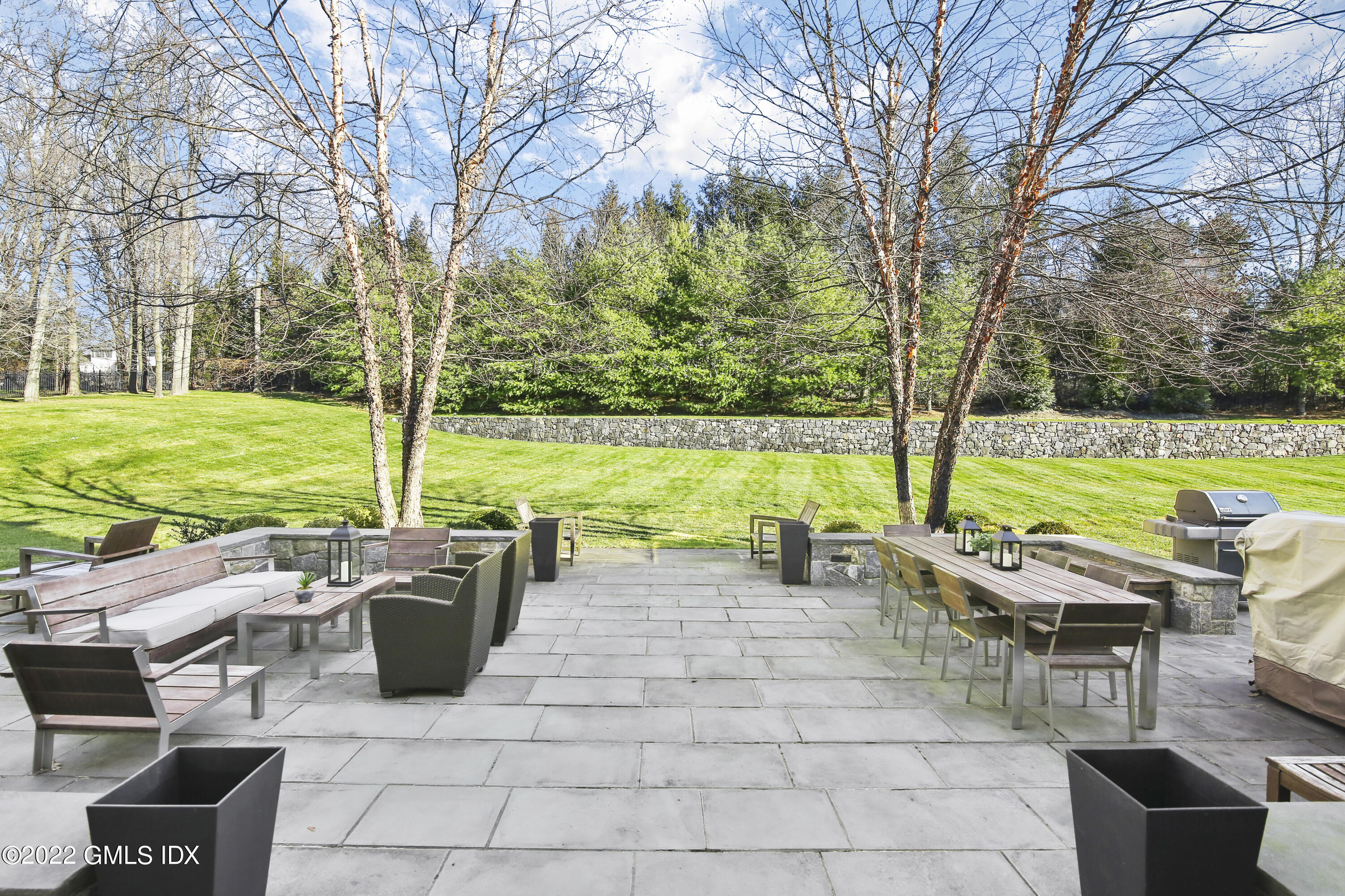 807 Lake Avenue Greenwich, CT 06830 - Photo 25 of 31 a view of a patio with table and chairs under an umbrella