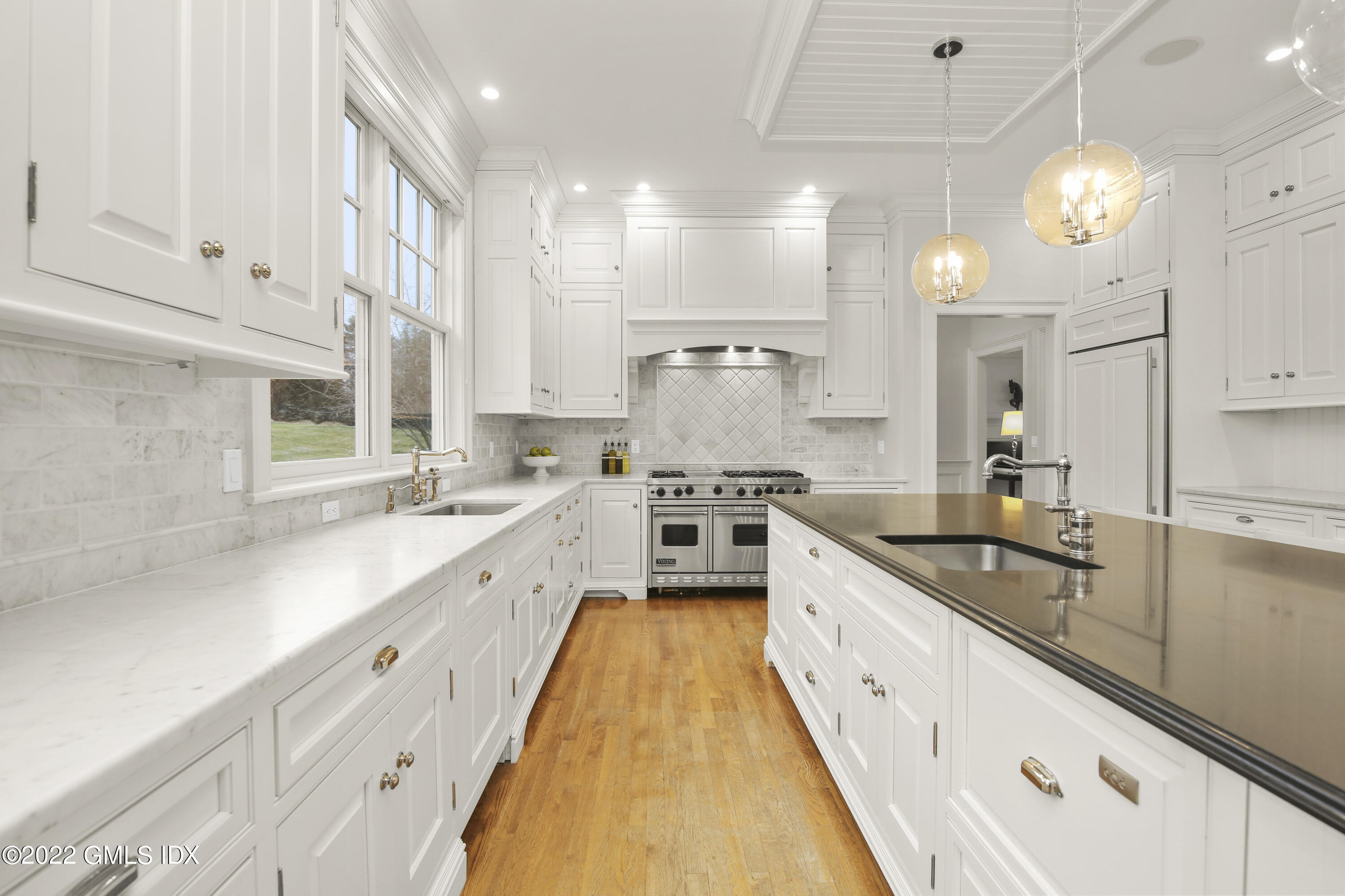 807 Lake Avenue Greenwich, CT 06830 - Photo 8 of 31 a large white kitchen with a large window a sink and cabinets