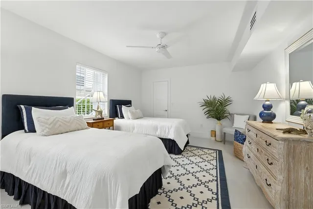 a spacious bedroom with two beds and a lamp