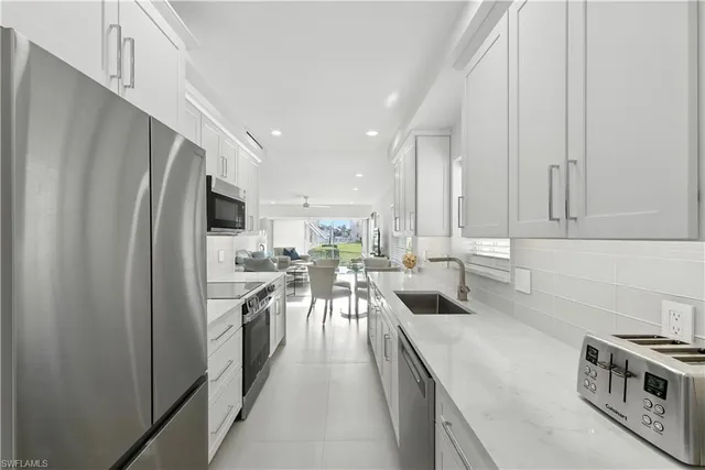 a kitchen with white cabinets and stainless steel appliances