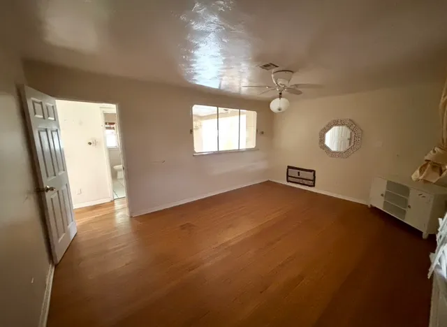 en empty room with windows and ceiling fan