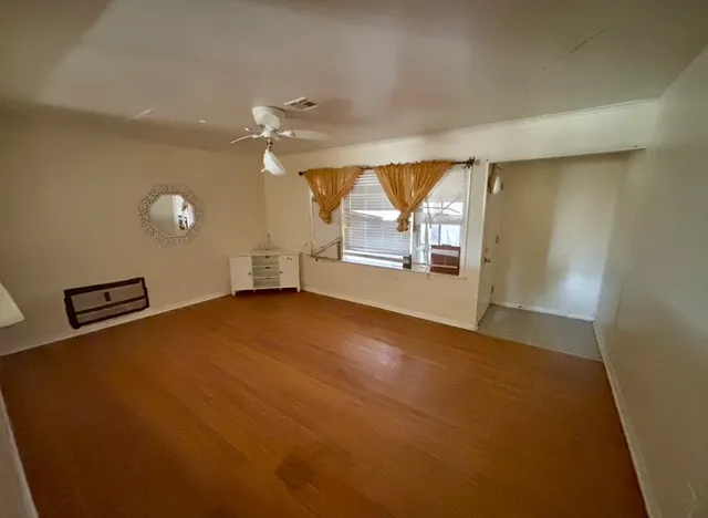 wooden floor in an empty room with a window