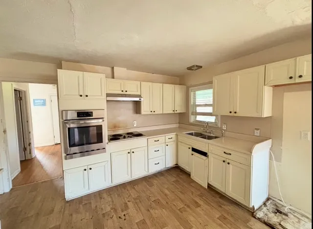 a kitchen with granite countertop white cabinets and white appliances