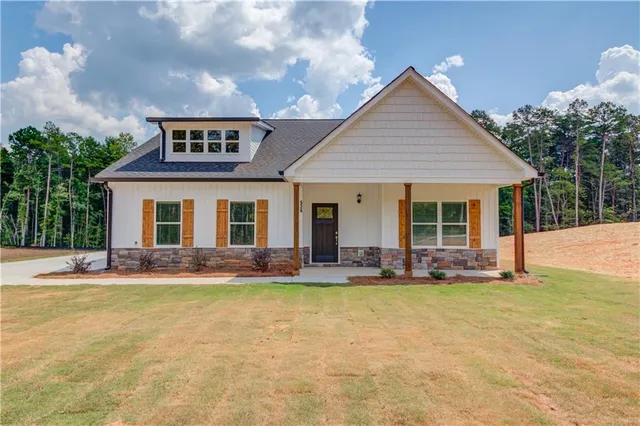 a front view of a house with a yard outdoor seating and garage