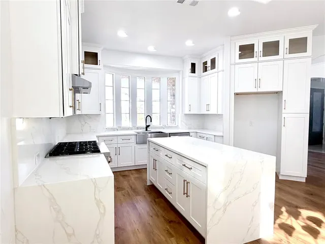a kitchen with a stove a sink a refrigerator and cabinets