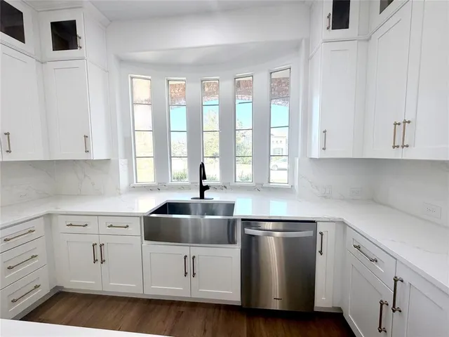a kitchen with white cabinets and white appliances