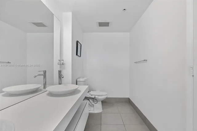 a bathroom with a double vanity sink mirror and shower