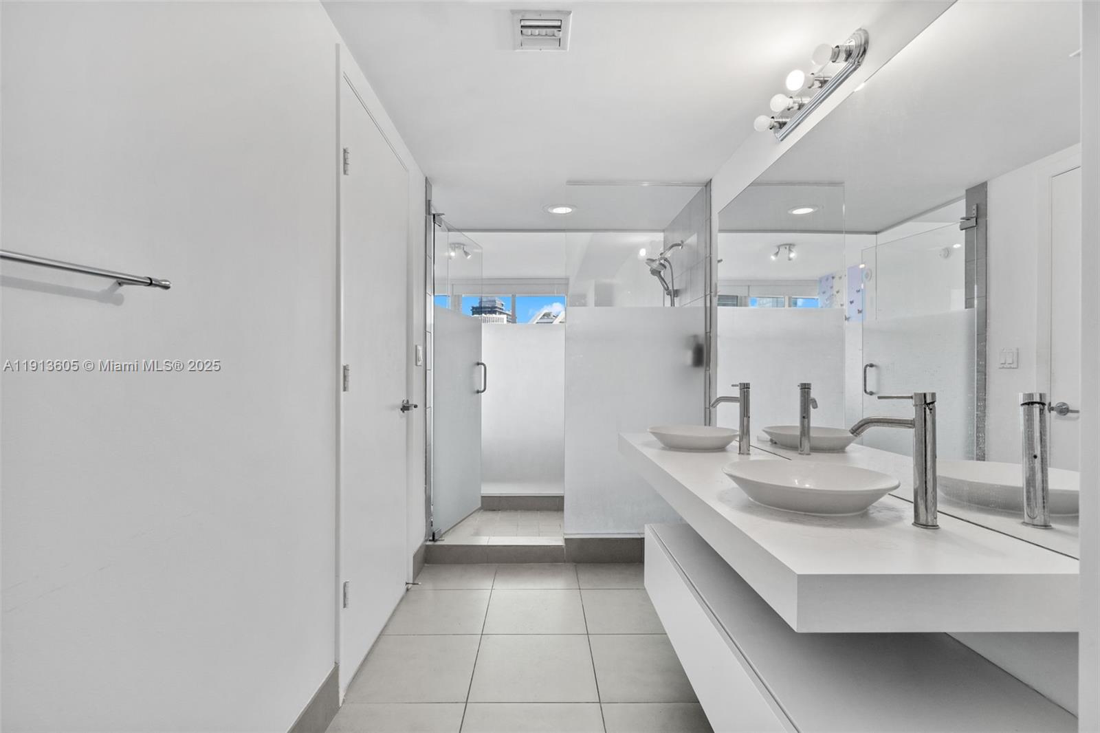 92 Southwest 3rd Street, Unit 4403 Miami, FL 33130 - Photo 16 of 28 a bathroom with a double vanity sink mirror and shower