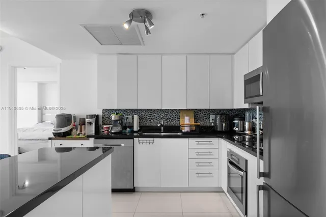 a kitchen with granite countertop a sink a stove and cabinets