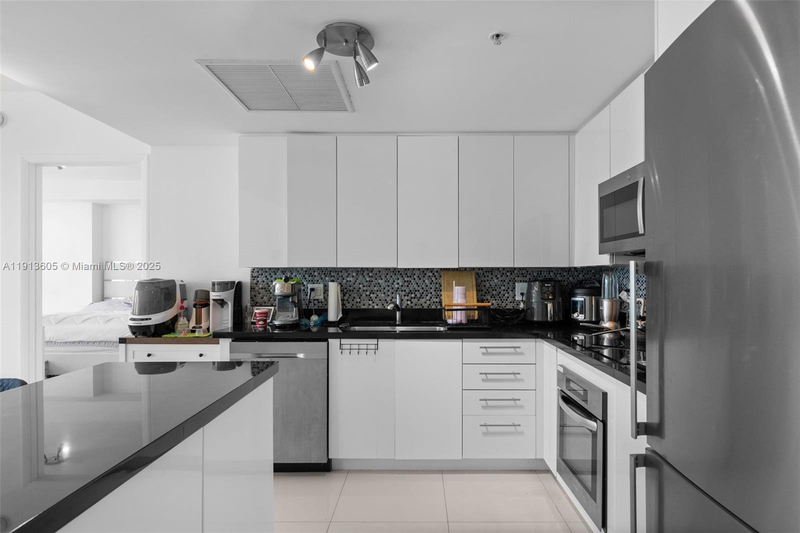 92 Southwest 3rd Street, Unit 4403 Miami, FL 33130 - Photo 4 of 28 a kitchen with granite countertop a sink a stove and cabinets