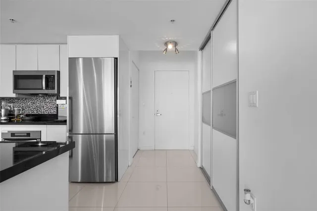 a kitchen with a sink a refrigerator and a stove top oven
