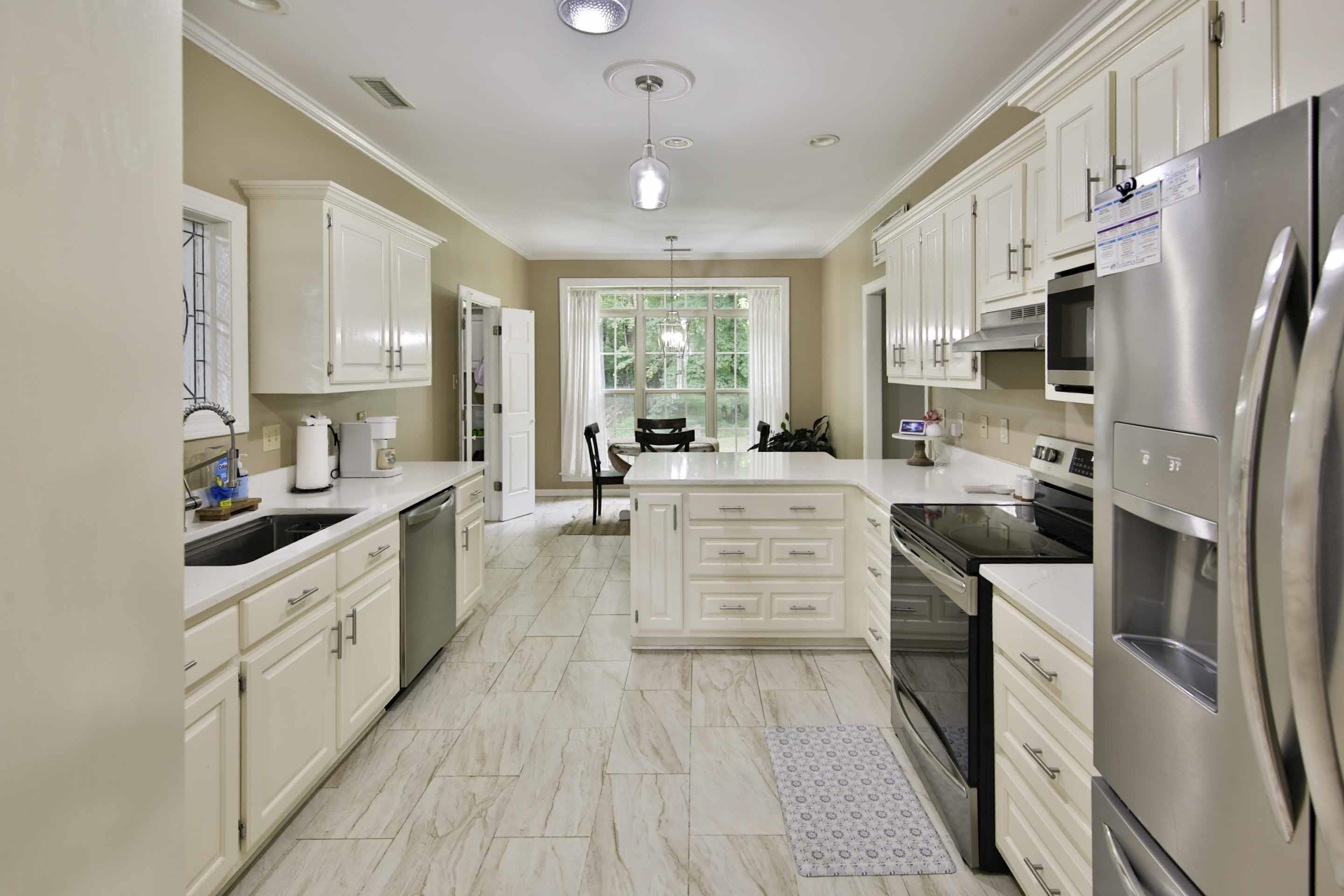 104 Miller Road Covington, TN 38019 - Photo 11 of 25 Kitchen featuring white cabinetry with brushed nickel hardware, light-toned countertops, stainless steel appliances, and large format tile flooring