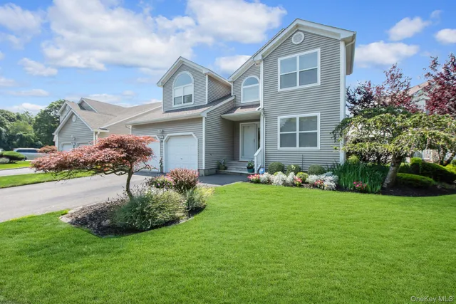 a front view of a house with a garden and plants