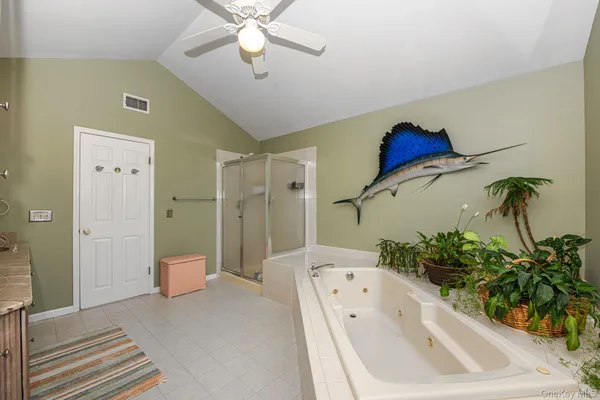 a spacious bathroom with a tub shower and a mirror